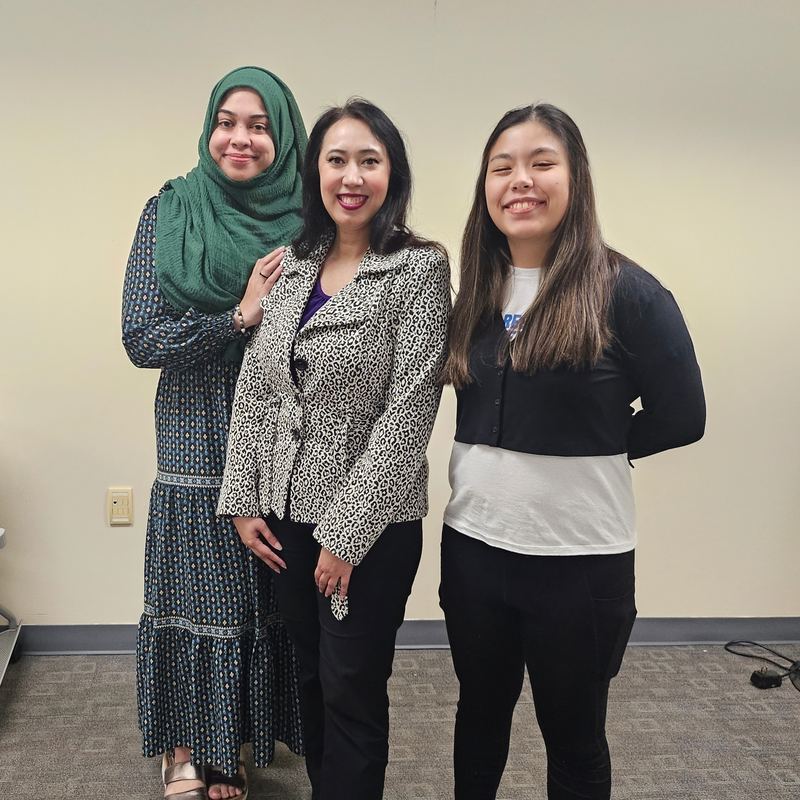 Three members standing together and smiling after a meeting
